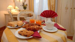 Een ontbijttafel met croissants, sap en een kopje.