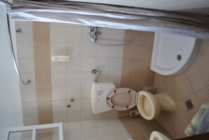 A bathroom with a toilet, shower, and sink. - Stelios Studios (Skiathos)