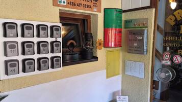 A wall with numbered room keys, a drop room key, and various signs including a rating and a TripAdvisor logo.