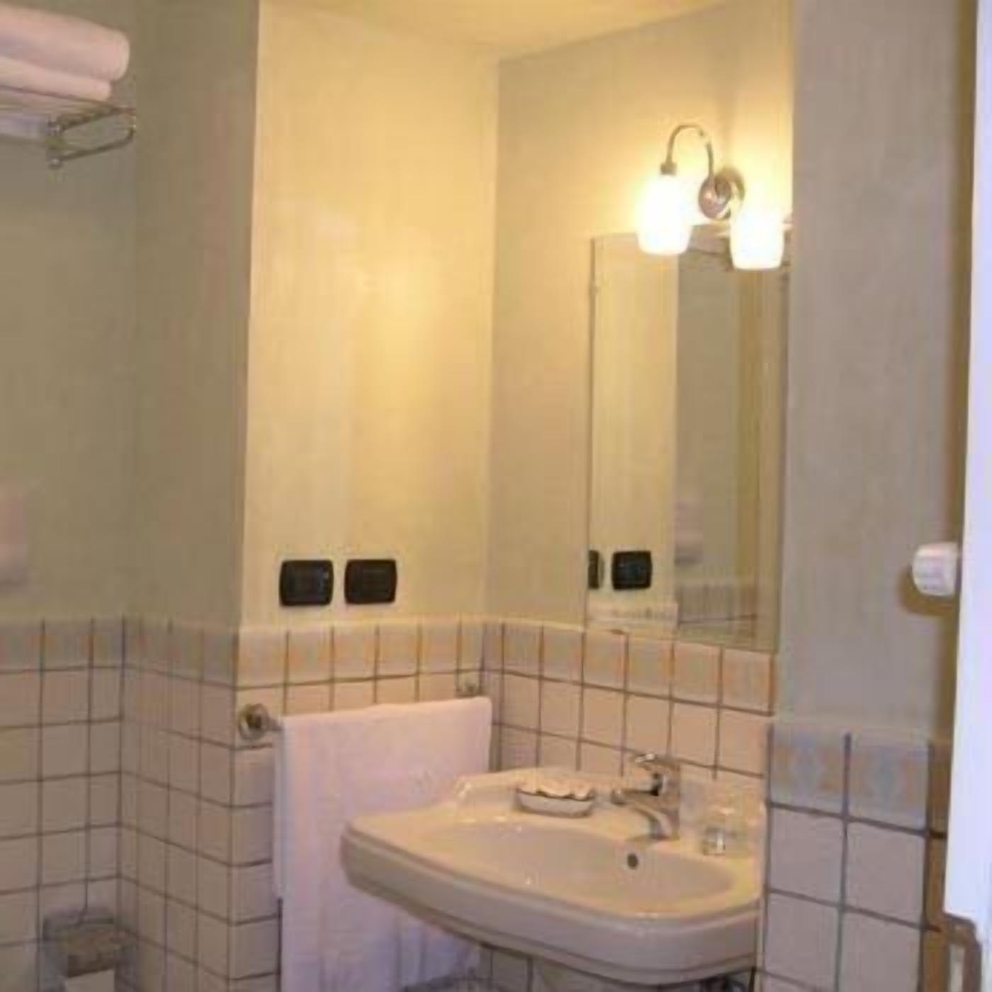Ein Badezimmer mit Waschbecken, Spiegel und gefliesten Wänden.