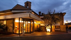 Un hôtel doté d’une entrée en verre, d’un clocher et d’une façade en briques.