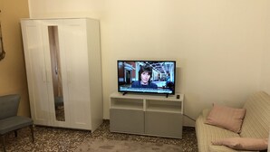 A living room with a television, a sofa, a cabinet, and a patterned rug. - B&B Accorsi (Bologna)