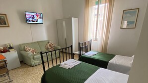 A room with two beds, a sofa, a television, and a wardrobe. - B&B Accorsi (Bologna)