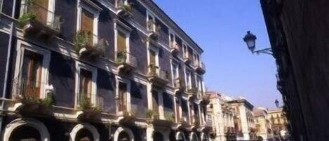 Una hilera de edificios históricos con ventanas arqueadas y balcones, característico de un paisaje urbano europeo.