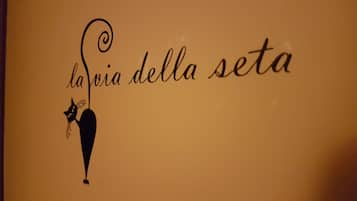 Eine Wand mit dem Schriftzug „la via della seta“ und der Silhouette einer Katze.