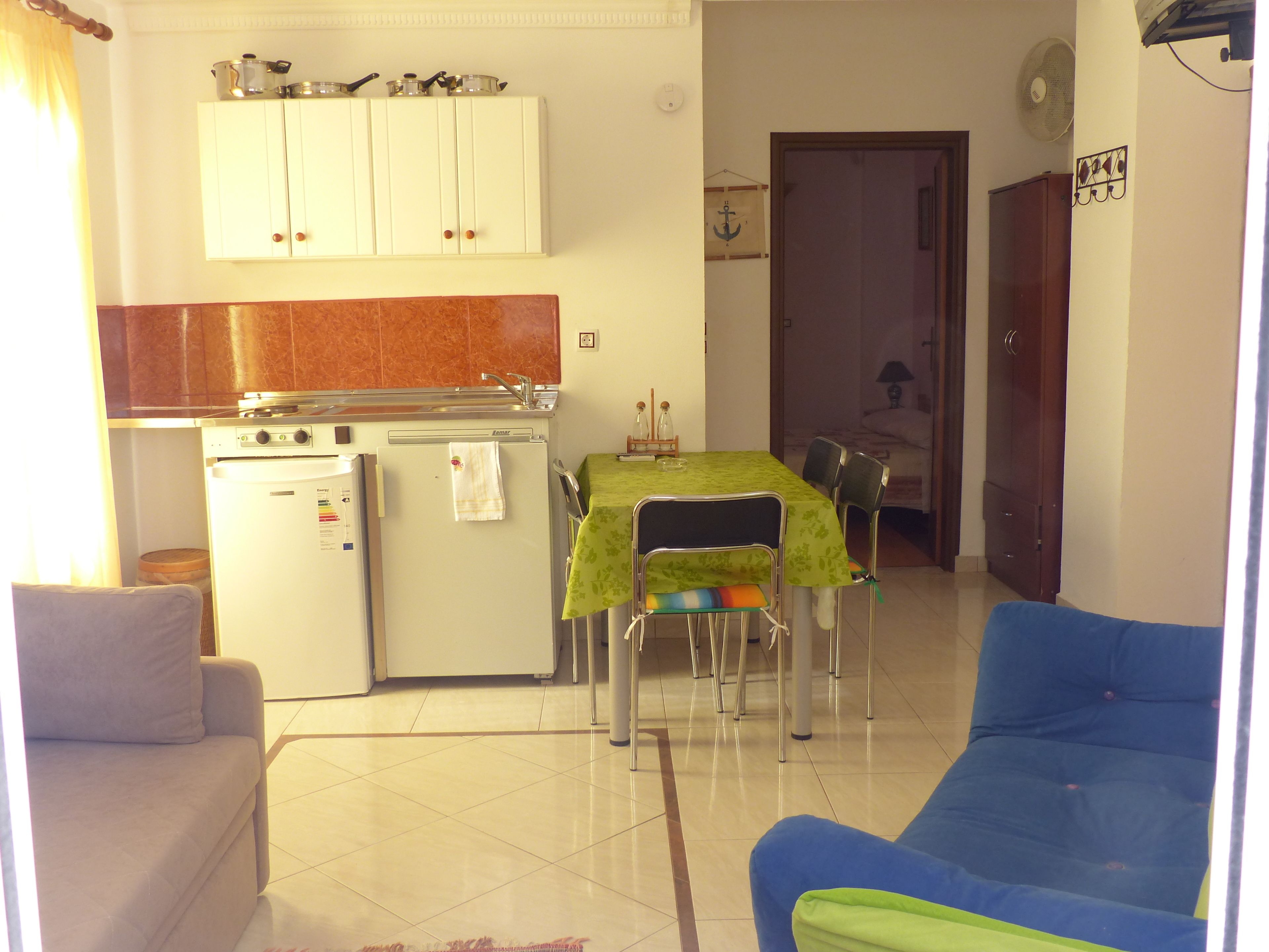 A compact living space with a kitchenette, dining area, and seating.