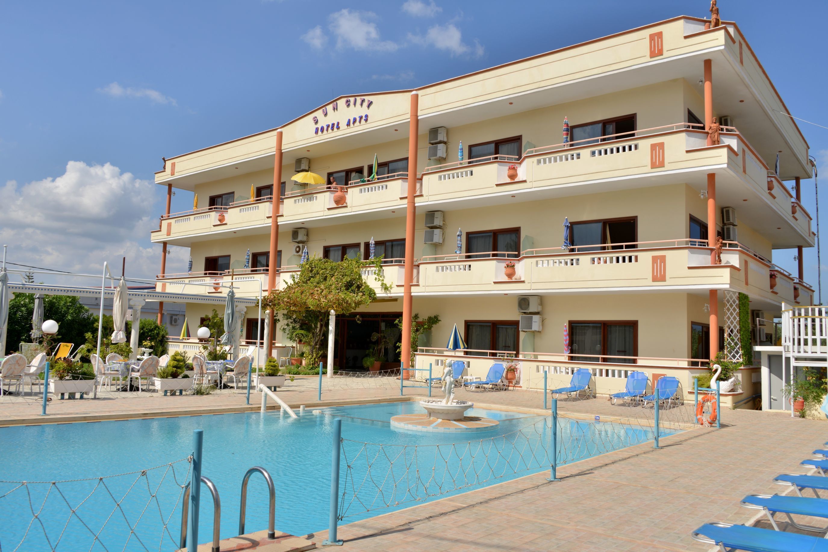 A hotel with a pool, multiple balconies, and outdoor seating.