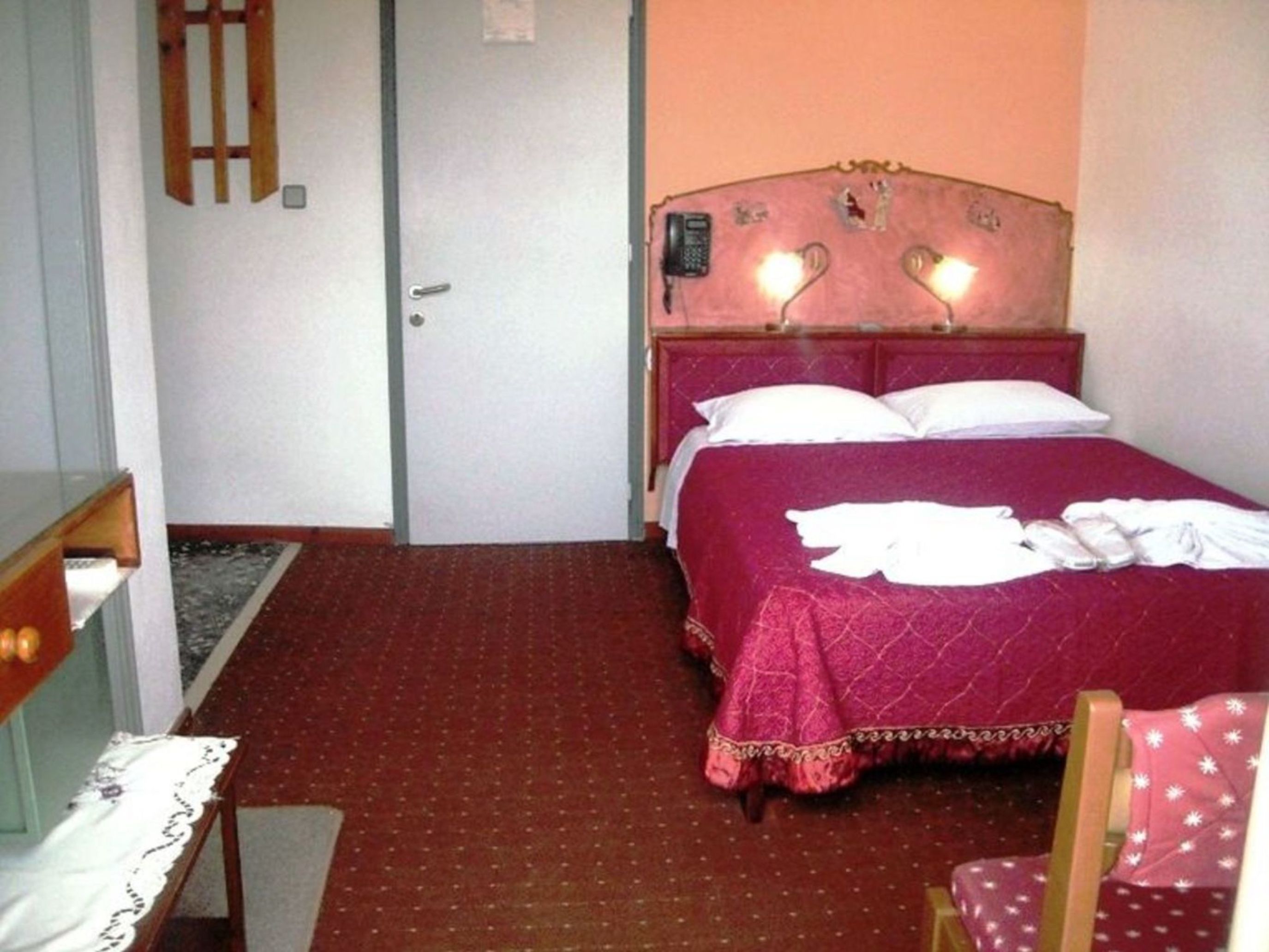 Hotellihuone, jossa on sänky, työpöytä ja tuoli.
