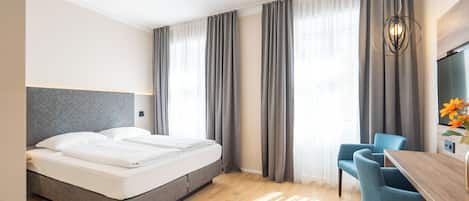 Una habitación de hotel moderna con una cama, un escritorio y una silla.