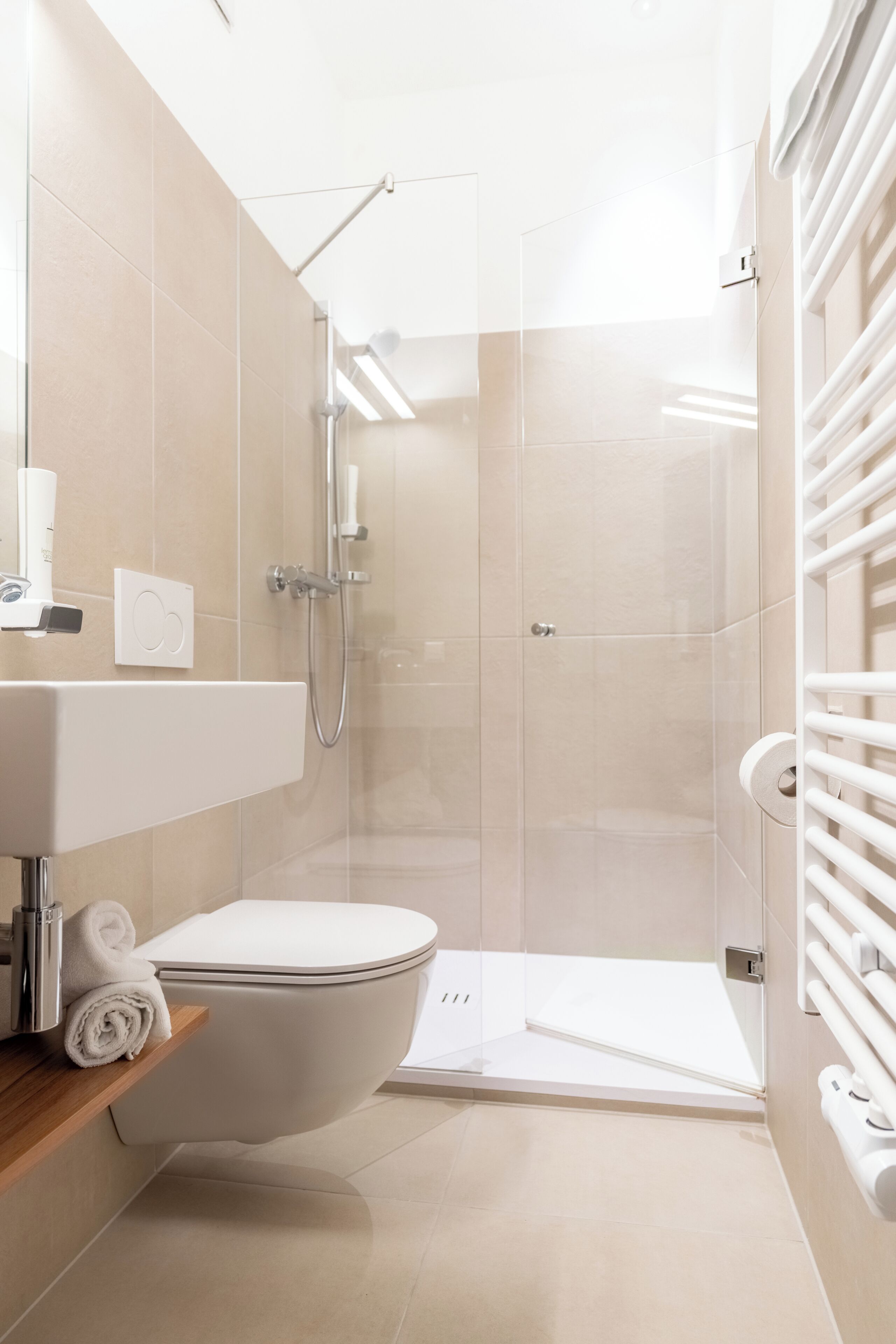 A modern bathroom with a toilet, shower, and sink.
