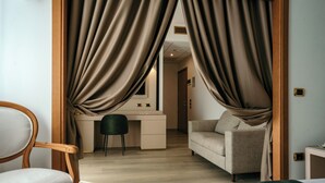 A hotel room with a bed, a desk, a chair, and a sofa. - Grand Hotel La Chiusa di Chietri (Alberobello)