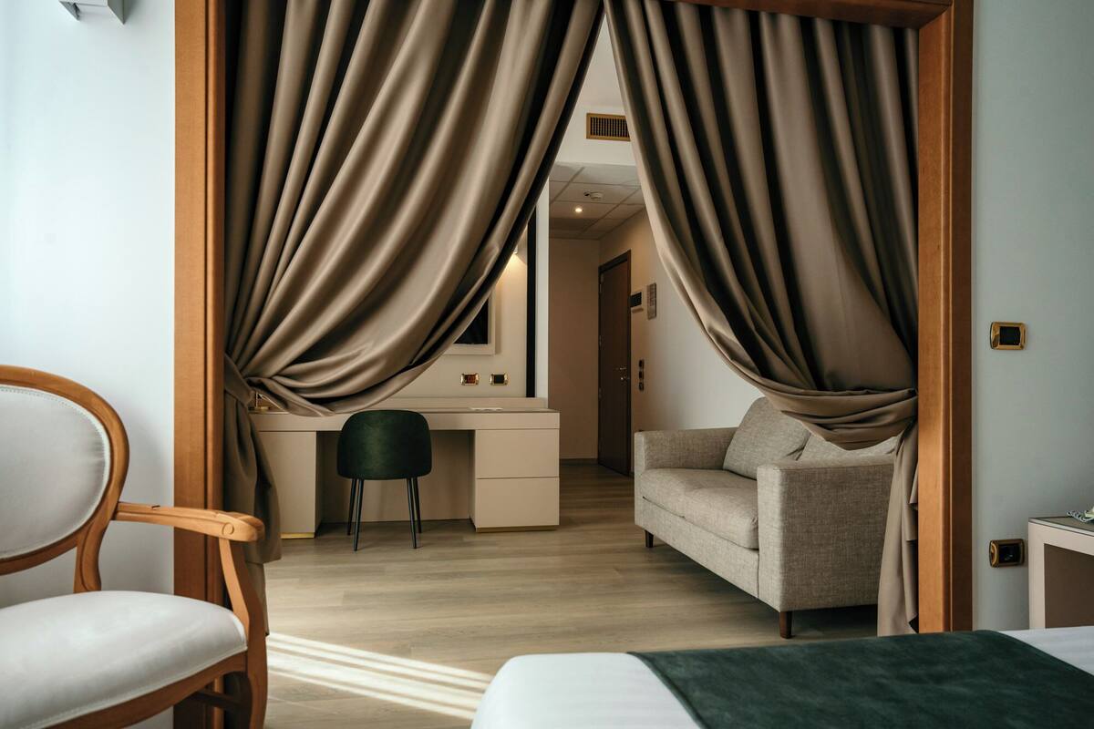 Une chambre d’hôtel avec un lit, un bureau, une chaise et un canapé.