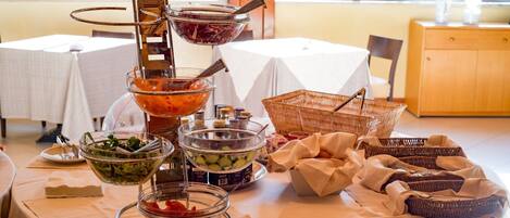 A buffet table with various food items and condiments.