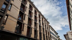 A multi-story building with balconies and a series of windows.