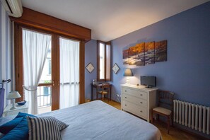 A bedroom with a bed, a desk, a chair, a dresser, and a TV. - B&B A Teatro (Florence)