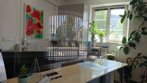 Una cocina moderna con un amplio ventanal, un cuadro de flores rojas y diversos electrodomésticos.