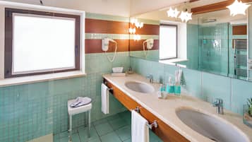 Un bagno con due lavabi, uno specchio e un asciugacapelli montato a parete.