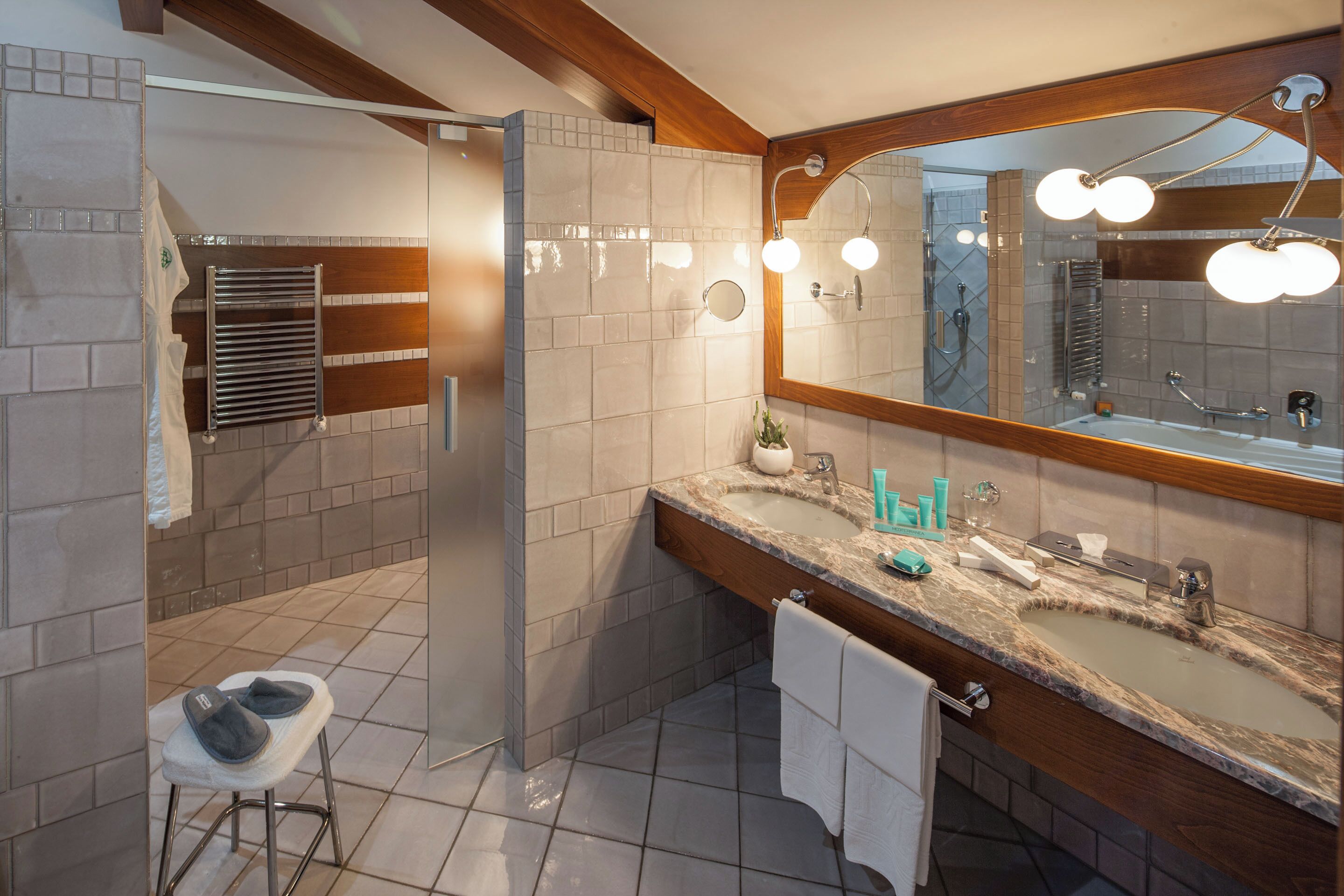 Een moderne badkamer met een douche, een wastafel met spiegel en een handdoekhouder.