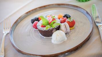 A dessert plate with various fruits and a scoop of ice cream.