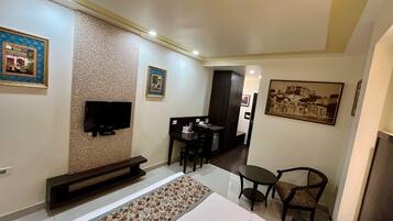 Une chambre d’hôtel avec un lit, une télévision, un bureau et une chaise.