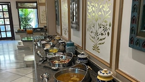 A buffet setup with various dishes and utensils. - Hotel Ratnawali (Jaipur)