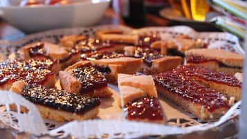 Variedad de postres en una bandeja, entre ellos pasteles y hojaldres con mermelada y nueces.