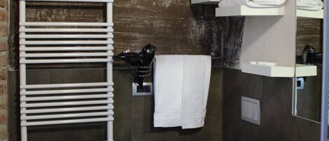 A bathroom with a white sink, a toilet, a towel rack, and a mirror.