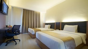 A hotel room with two beds, a desk, a chair, and a TV mounted on the wall. - Hanoi Discovery Hotel (Hanoi)