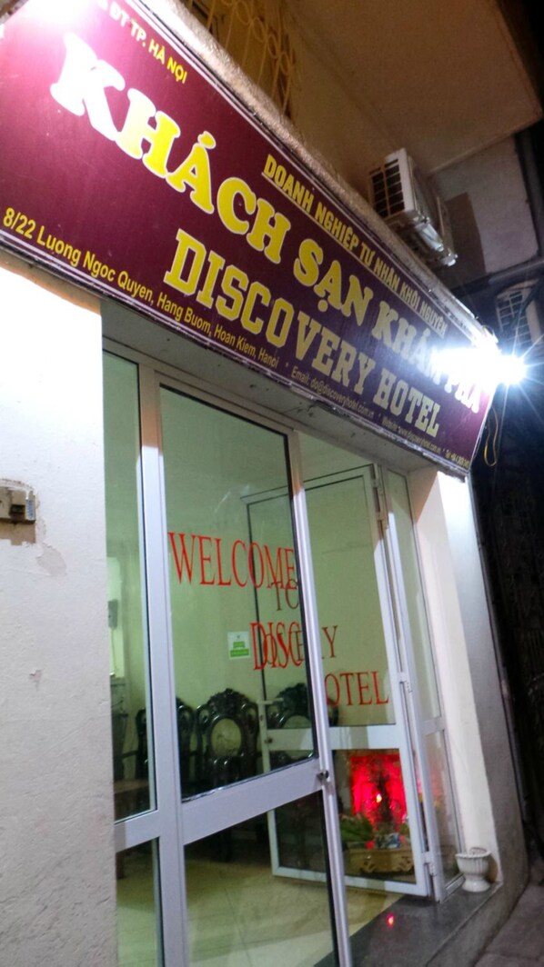 Entrada de un hotel con un cartel que dice "KHÁCH SAN KHÁCH DISCOVERY HOTEL".