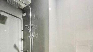 A modern bathroom with a shower, toilet, and a door. - Hanoi Discovery Hotel (Hanoi)