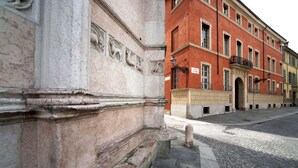 Un edificio histórico con arquitectura clásica, que incluye detalladas esculturas de piedra y fachada roja.