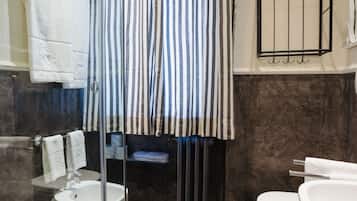Un baño moderno con ducha de vidrio, inodoro blanco y bañera.