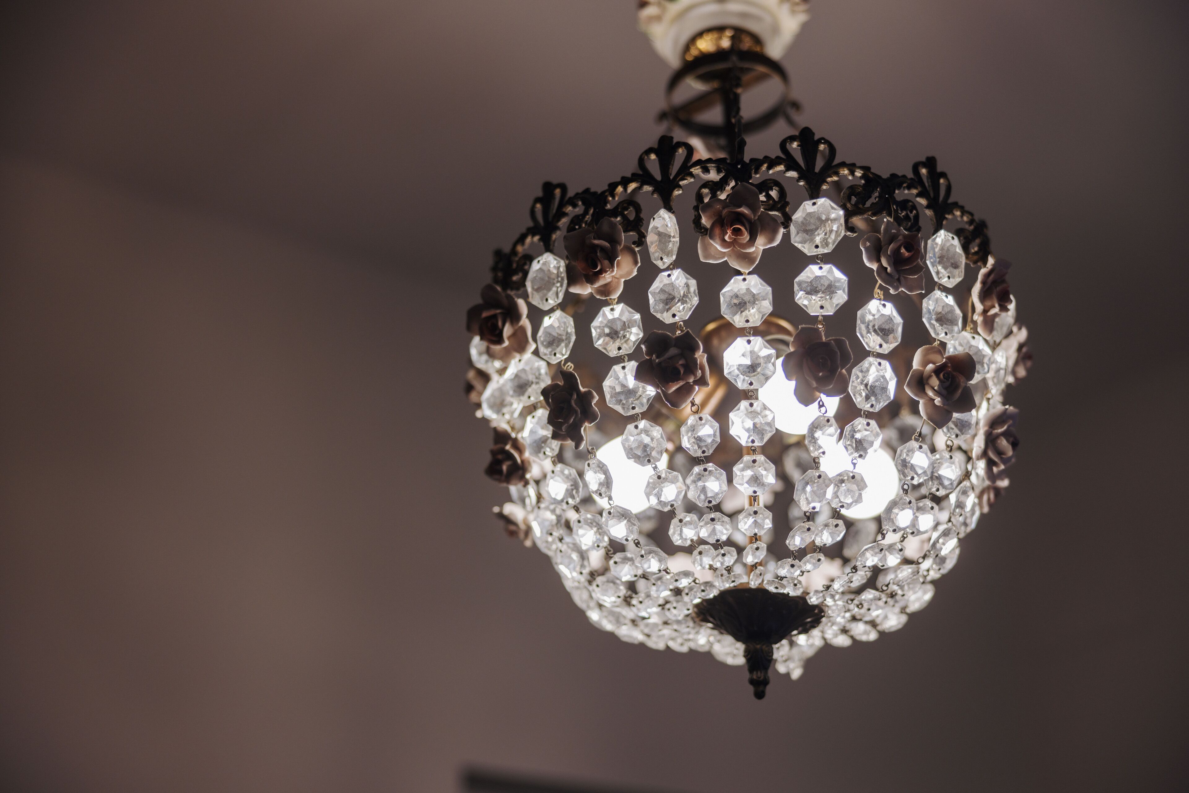 A chandelier with multiple crystal elements and a central dark fixture.