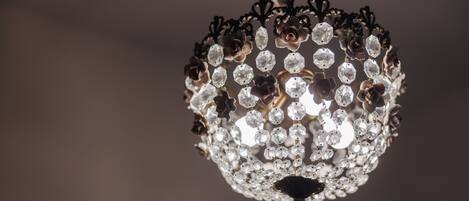 A chandelier with multiple crystal elements and a central dark fixture.