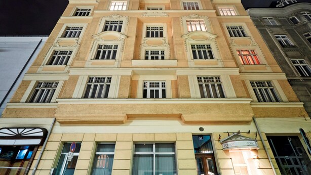Um edifício de vários andares com arquitetura clássica, caracterizado por janelas simétricas e detalhes decorativos.