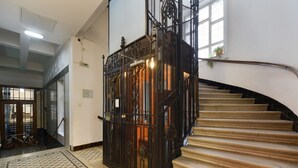 Uma escadaria com guarda-corpos de metal detalhados e um tapete estampado.