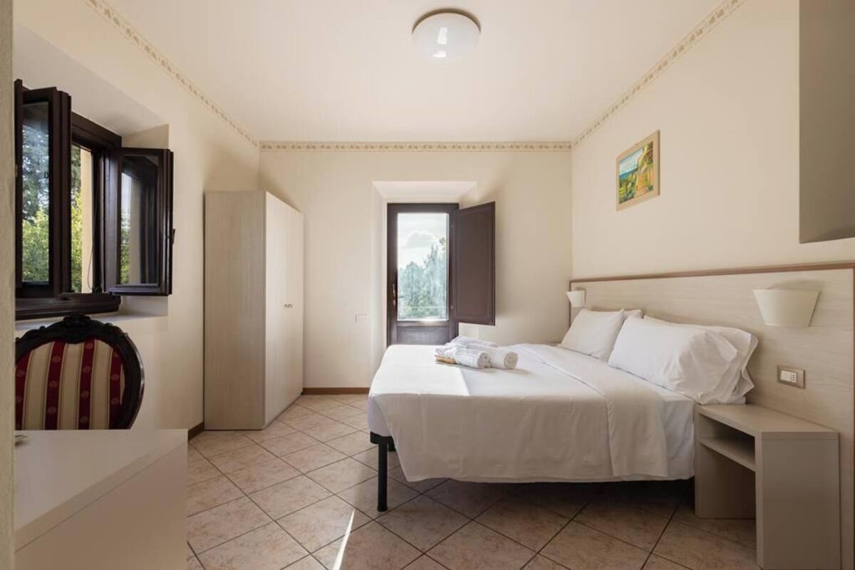 Une chambre à coucher avec un lit, une table de chevet et une fenêtre.