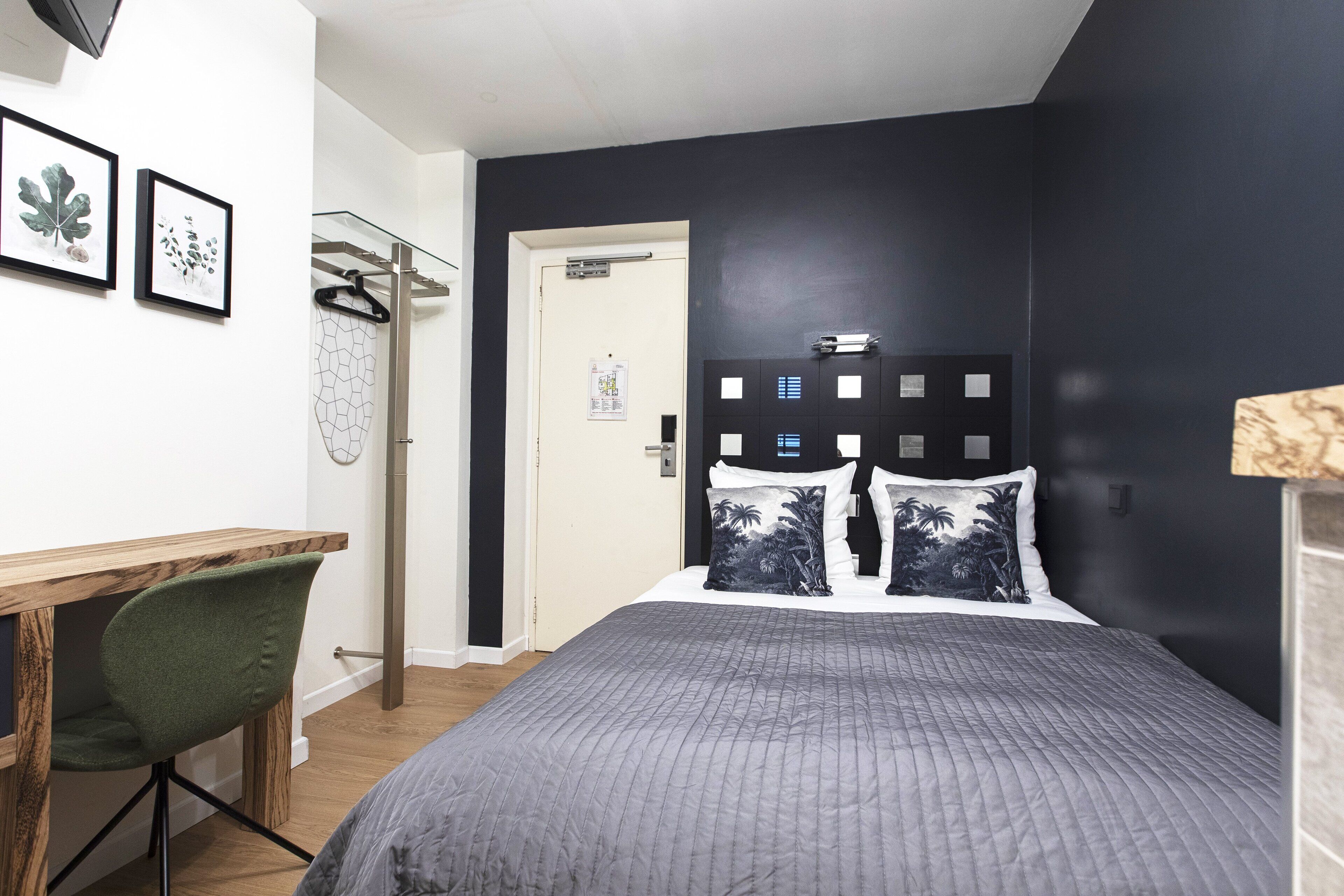 Um quarto com uma cama, uma escrivaninha e uma cadeira.
