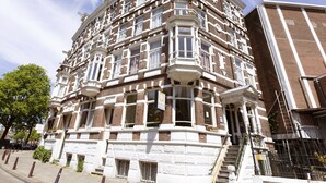 A corner building with multiple windows and balconies, featuring a traditional architectural style. - Quentin Canal House Hotel (Amsterdam)
