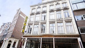 Ein historisches Gebäude mit einem gut sichtbaren 'HOTEL'-Schild, großen Fenstern und klassischer Architektur.