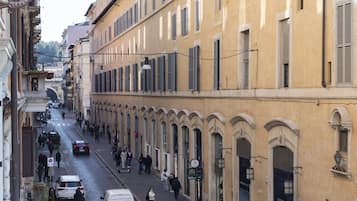 A street lined with historic buildings, a crosswalk, and pedestrians.