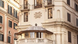 A historic building with classical architecture, featuring a central dome and multiple balconies. - Hotel Scalinata di Spagna (Rome)