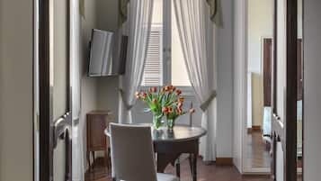 A dining area with a table, chairs, and a vase of flowers.