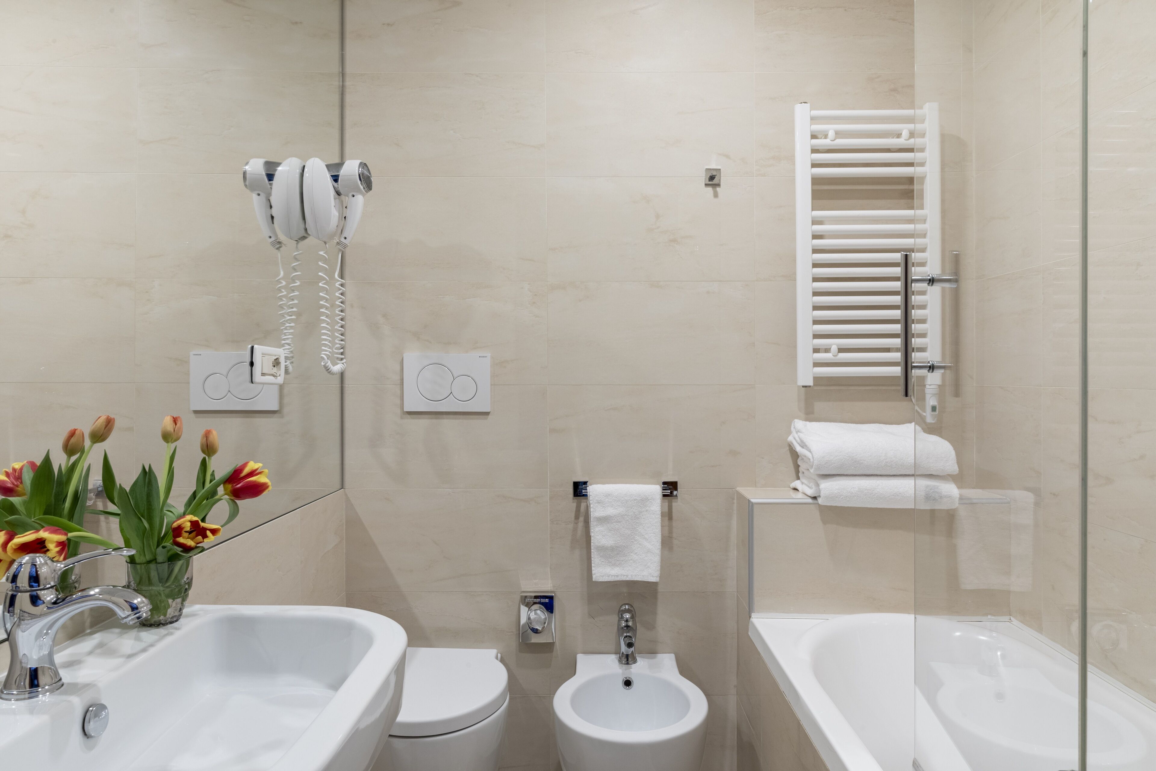 Un baño moderno con lavamanos, bidé, inodoro y bañera.