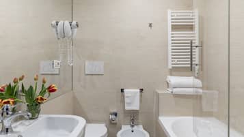 Et moderne badeværelse med håndvask, toilet, badekar og pissoir.