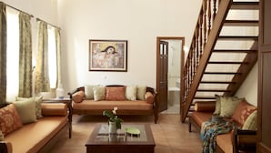 A living room with a sofa, a coffee table, and a staircase. - Palazzo Vecchio Exclusive Residence (Rethymno)