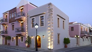 A multi-story hotel with balconies, a stone column, and a street lamp. - Palazzo Vecchio Exclusive Residence (Rethymno)