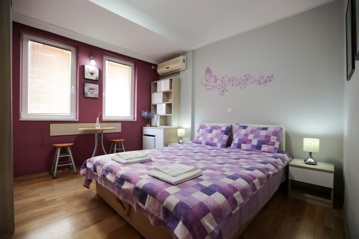 A bedroom with a bed, a desk, and a chair.