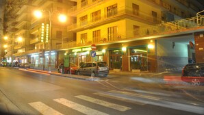 Un hotel de varios pisos con balcones y un restaurante en la planta baja.