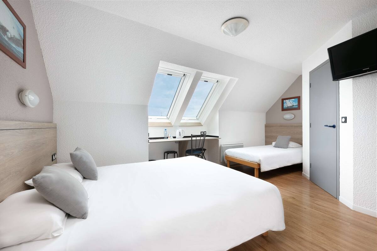 Een moderne hotelkamer met een groot bed, een bureau en een televisie.